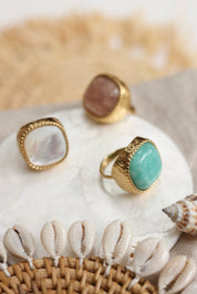 Bague dorée Lylou quartz fraise ajustable ornée d'une grosse pierre carrée au bords arrondis - Bijou photographié dans un décor estival