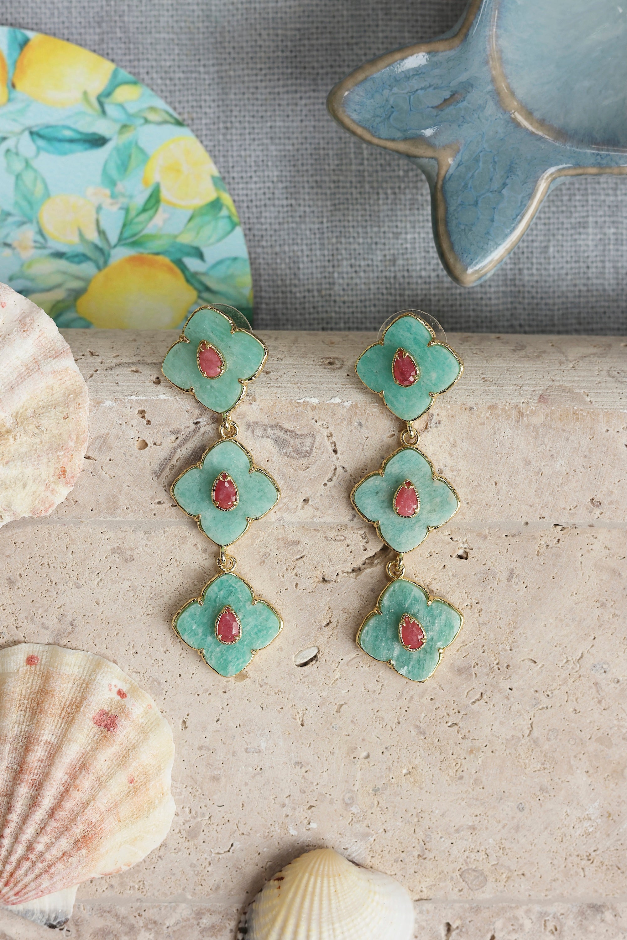 Boucles d'oreilles pendantes dorées Janyce amazonite ornées de pierres naturelles - Bijou photographié dans un décor estival