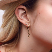 Boucle d'oreille à l'unité dorée avec chaîne pendante et zircons - Bijou porté