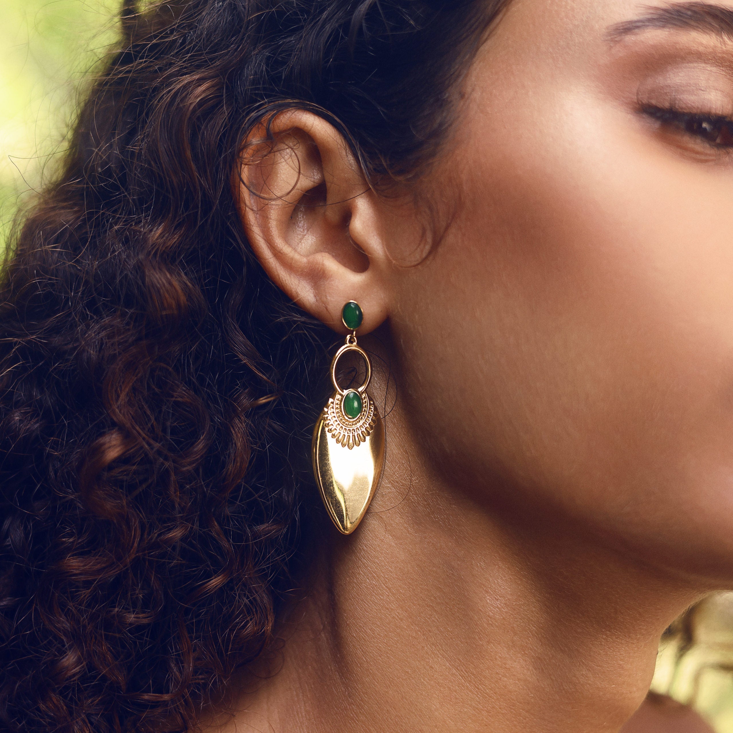 Boucles d’oreilles pendantes dorées avec des détails verts - Bijou porté