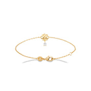 Bracelet doré avec un pendentif nœud de l’infini et un zircon en forme de goutte suspendu - Bijou photographié sur fond blanc 