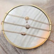 Bracelet doré Mayaan, zircon central entouré de petits zircons - Bijou photographié sur miroir rond