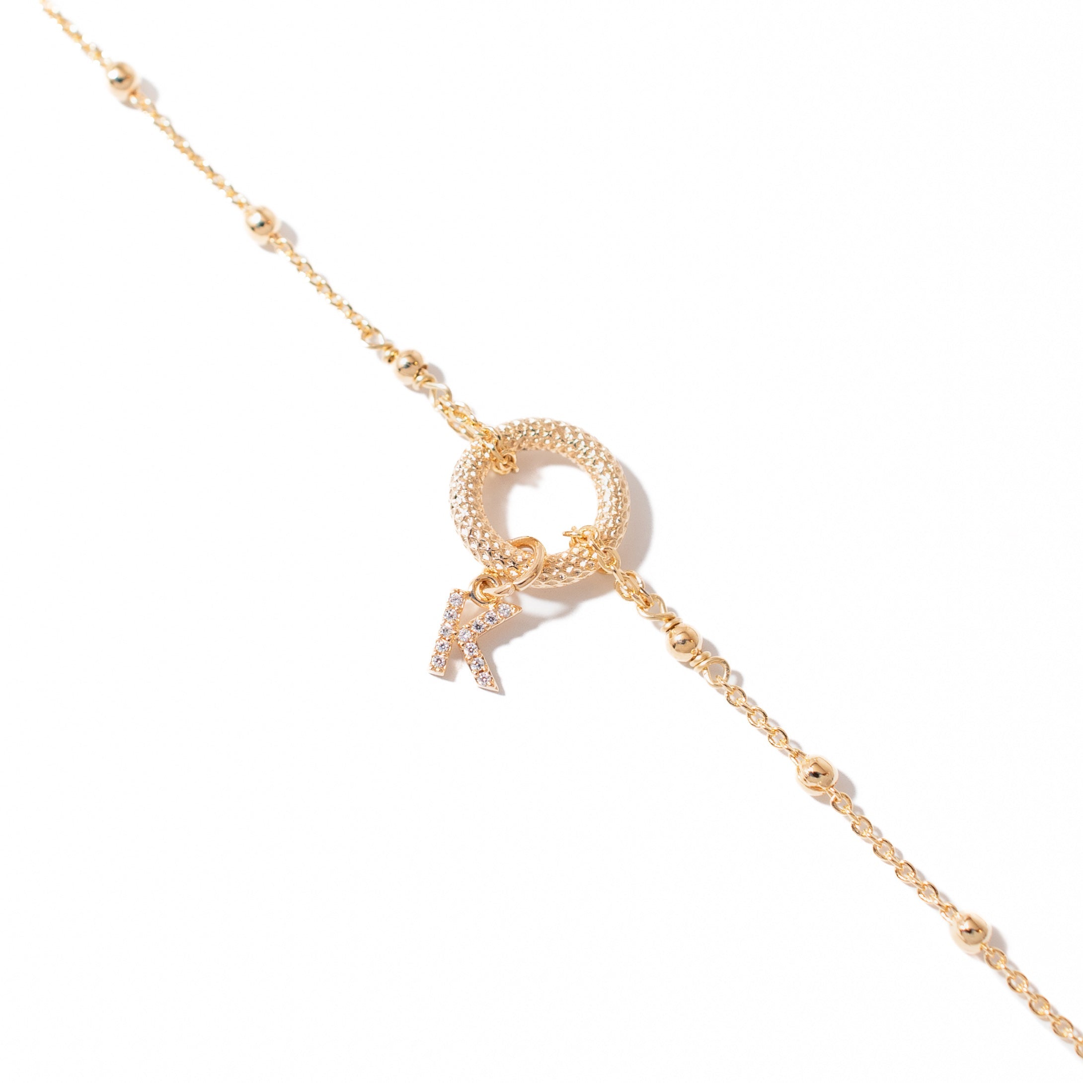 Bracelet personnalisable doré zircons charms et initiales Oka - Bijou photographié sur fond blanc