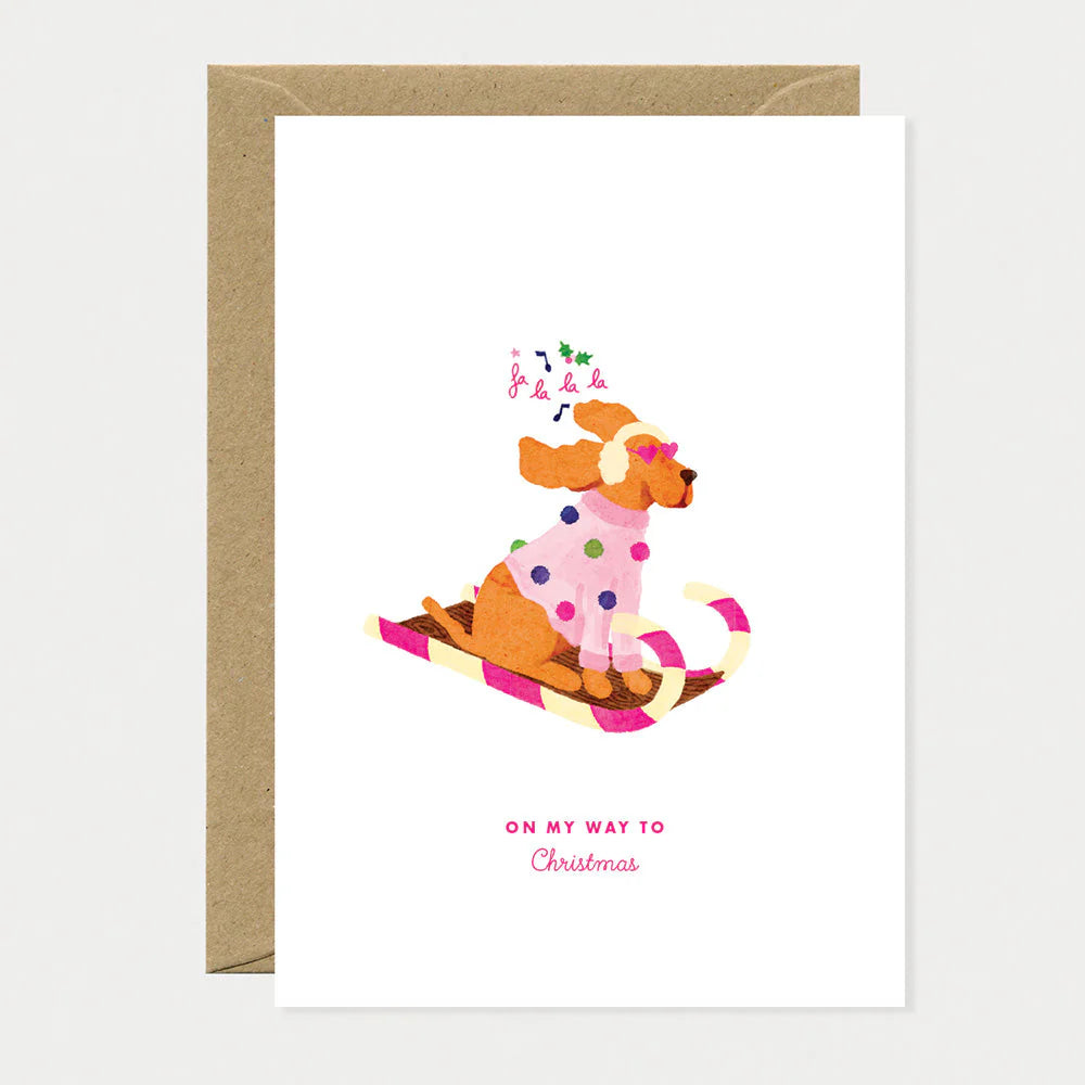 Carte de Noël en papier naturel blanc avec un chien qui fait de la luge - Papeterie