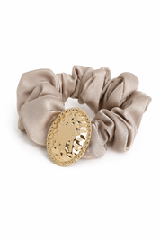 Élastique chouchou ovale martelé effet satiné orné d'un ovale martelé doré - Accessoire sur fond blanc