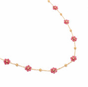 Collier doré Malou orné de petites fleurs fuchsia - Bijou photographié sur fond blanc 
