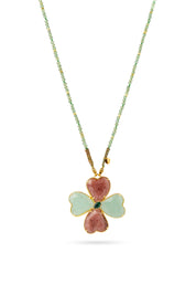 Collier sautoir Malaurie sur fil doré composé de perles en aventurine avec un pendentif en forme de trèfle serti d'aventurine, de quartz fraise et de malachite - Bijou sur fond blanc