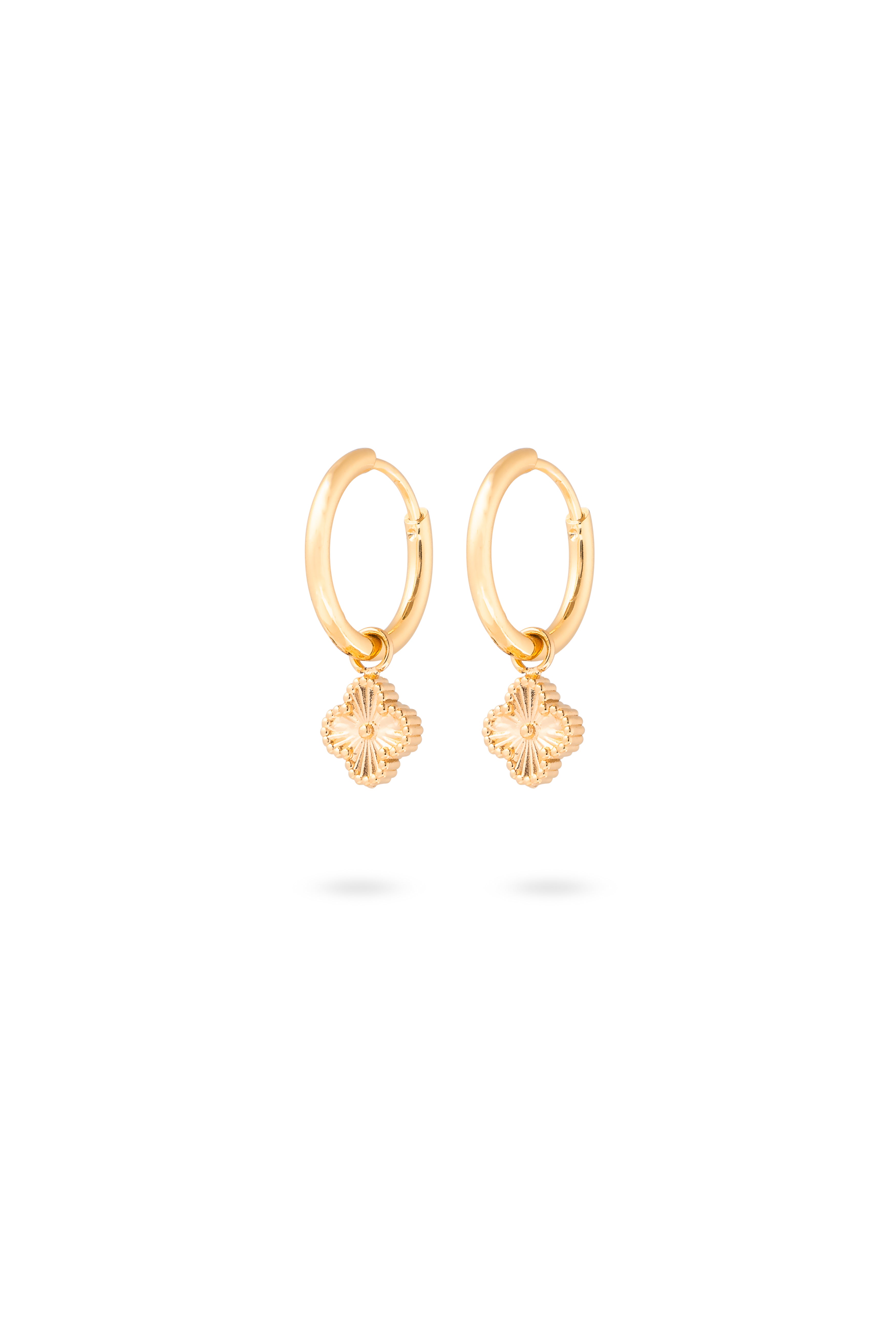 Boucles d'oreilles mini créoles dorées Keria avec pendentif trèfle texturé - Bijou photographié sur fond blanc