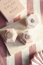 Médaille ronde Louisa S avec bordure en argent pour gravure - Bijou photographié dans un décor rose et blanc avec les autres médailles Louisa de taille différente