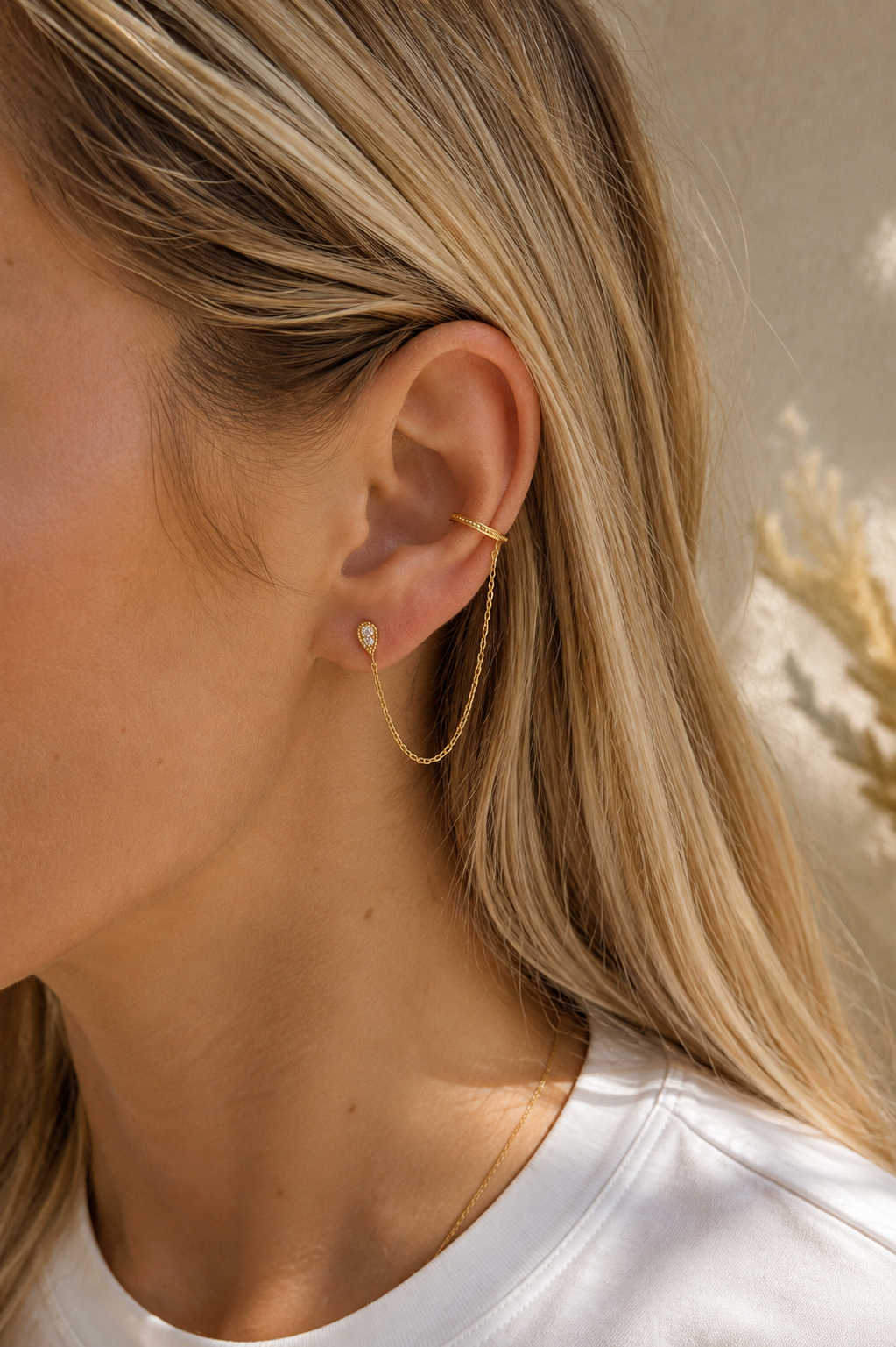 Boucle d'oreille monoboucle Adriana à l'unité dorée composée d’une puce en forme de goutte et d’une bague d’oreille reliées par une fine chaîne - Bijou porté
