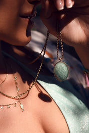 Collier sautoir Hinaya amazonite doré à chaîne torsadée avec pendentif ovale en pierre au dos orné de motifs floraux et serti d’un zircon central - Bijou porté
