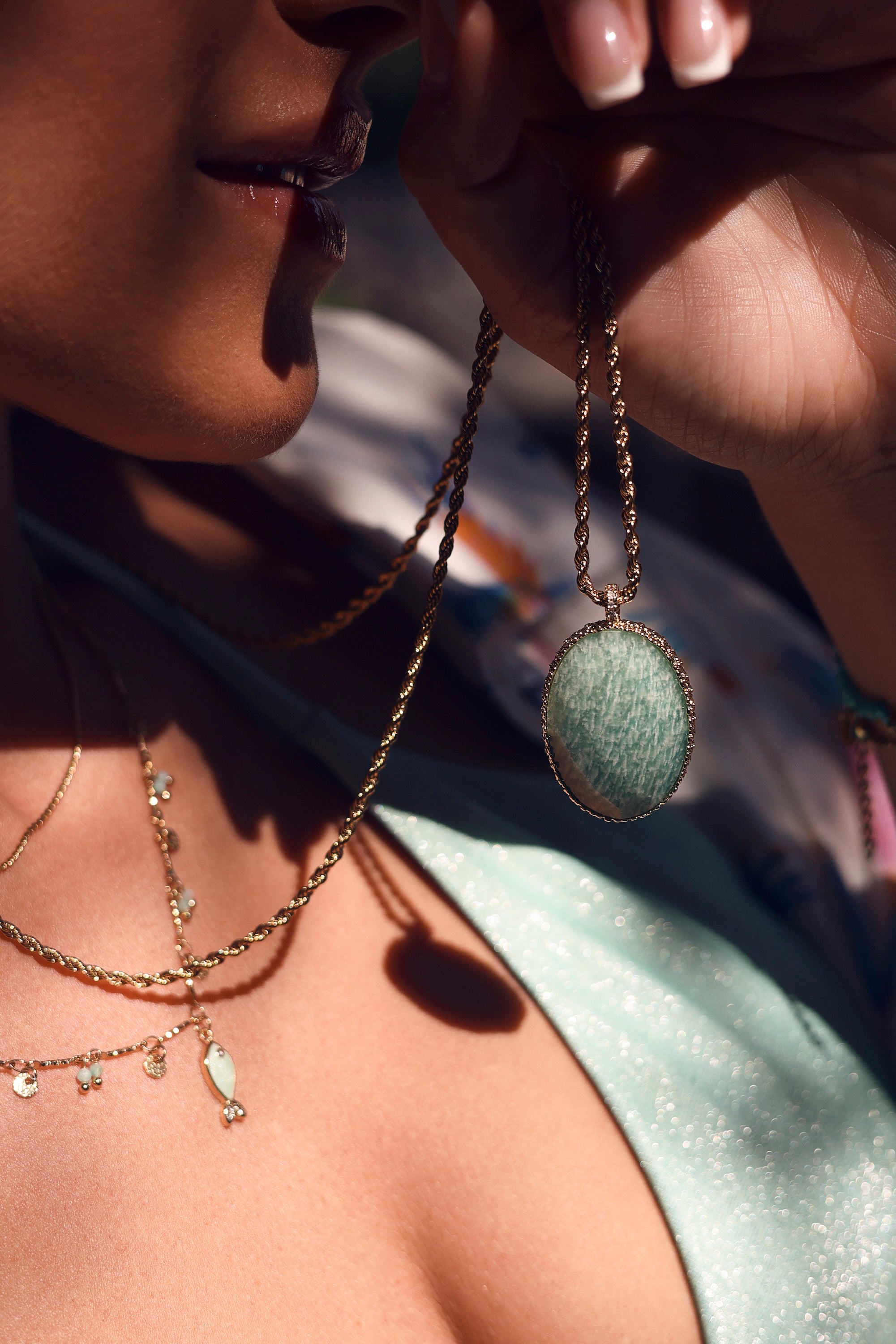 Collier sautoir Hinaya amazonite doré à chaîne torsadée avec pendentif ovale en pierre au dos orné de motifs floraux et serti d’un zircon central - Bijou porté