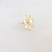  Bague dorée Gede fleur avec zircon central - Bijou photographié sur fond beige