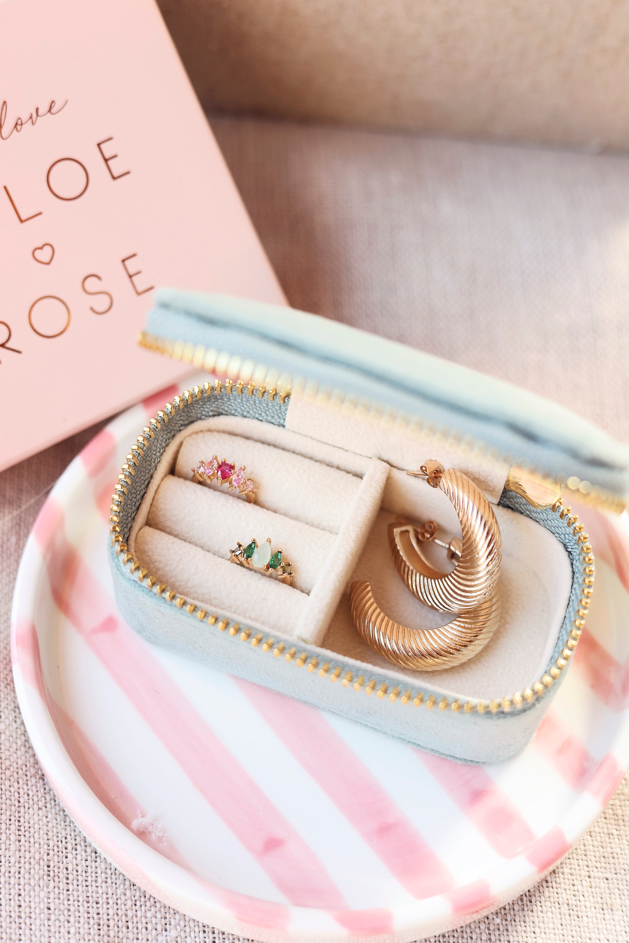 Bague d’oreille dorée Phil rose ornée de zircons roses - Bijou photographié dans une boîte à bijoux Chloe rose
