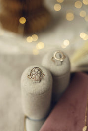 Bague dorée Jamila à motifs orientaux - Bijou photographié sur un présentoir en lin