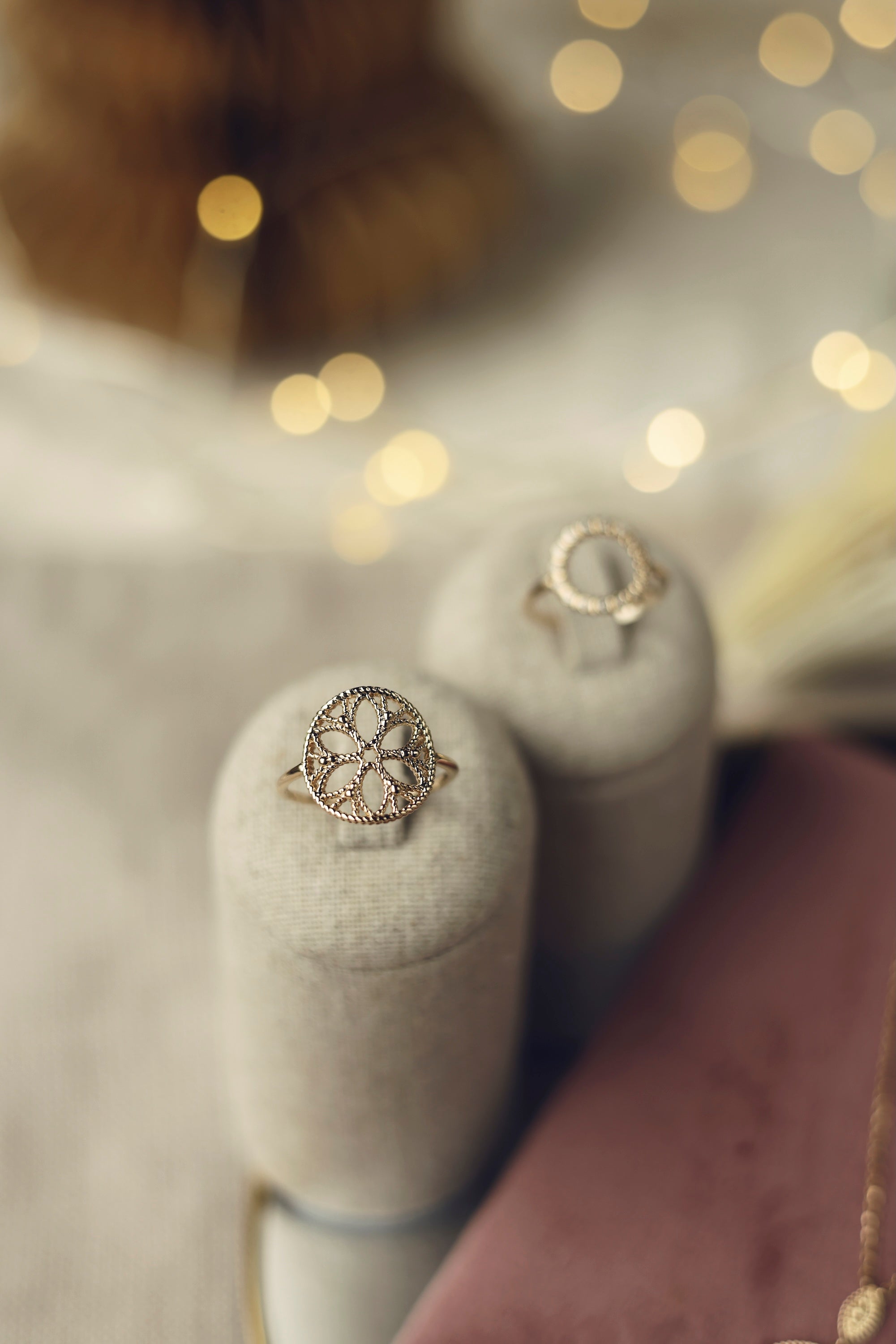 Bague dorée Jamila à motifs orientaux - Bijou photographié sur un présentoir en lin