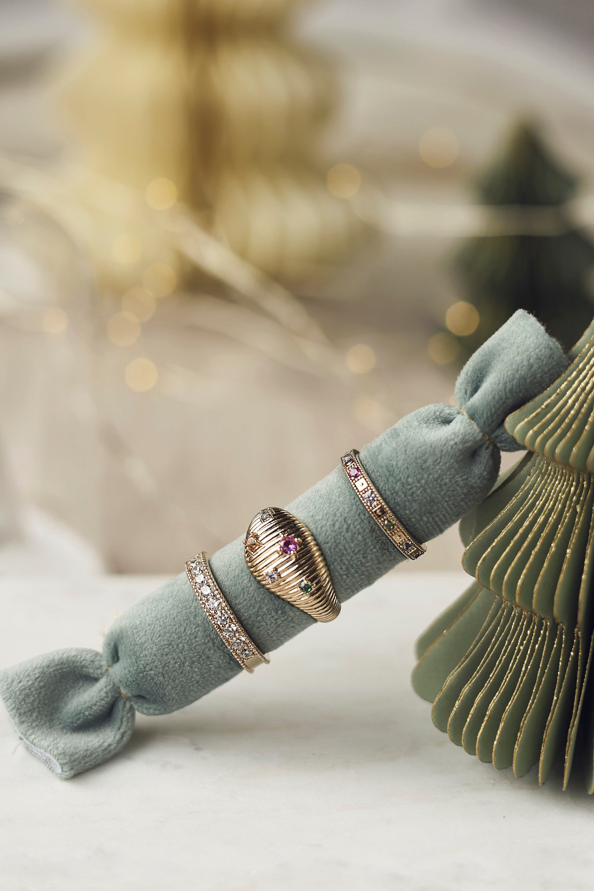 Bague dorée Marla de type anneau sertie de zircon - Bijou photographié sur un coussin bleu turquoise posé sur un sapin de Noël