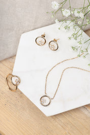 Boucles dorées Dayana cercle avec zircons - Bijou photographié sur marbre avec fleurs blanches