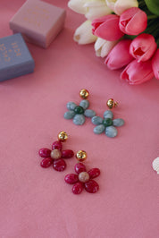 Boucles d'oreilles pendantes dorées Marty vert en acétate - Bijou photographié sur tissu rose avec tulipes et boites cadeau Chloe Rose
