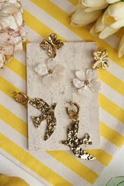 Boucles d'oreilles pendantes dorées fleurs Elwenn - Bijou photographié dans un décor estival