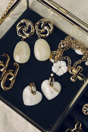 Boucles d'oreilles pendantes dorées Nali crème avec pendentif en acétate coloré - Bijou photographié dans une boîte à bijoux en velours vert