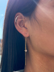 Boucles d'oreilles pendantes dorées ornées d'un trèfle en nacre au contour perlé - Bijou porté