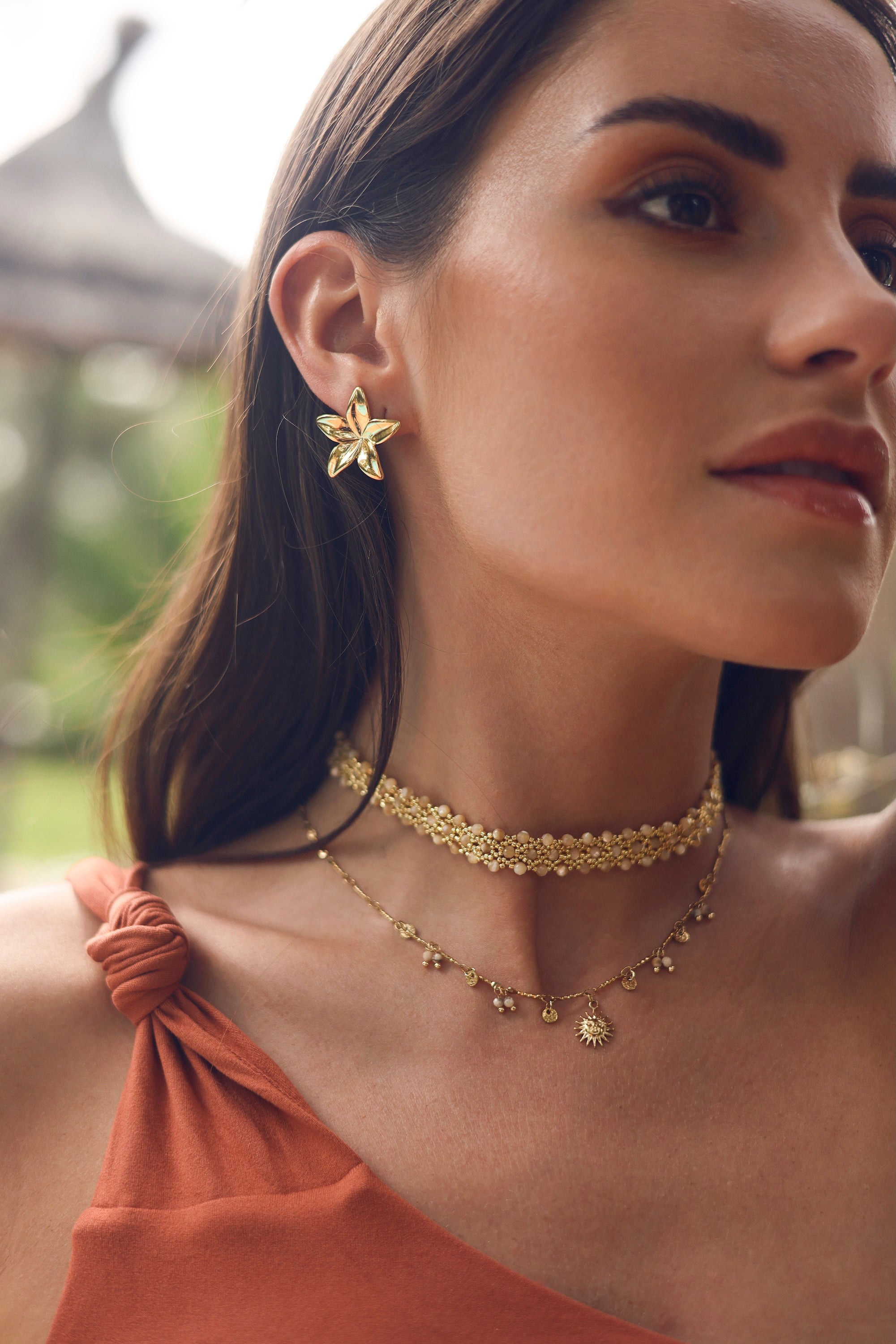 Boucles d'oreilles puces dorées Sensa en forme de fleur de frangipanier - Bijou porté