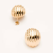 Boucles d'oreilles dorées Sonya - Bijou photographié sur fond beige