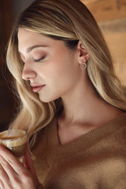 Boucles d'oreilles pendantes dorees Enora au design circulaire serties de zircons - Bijou porté