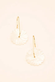 Boucles dorées Jasmina avec fleur en nacre - Bijou photographié sur fond beige