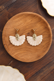 Boucles d’oreilles pendantes Luh écru en forme d’éventail - Bijou photographié dans un décor estival