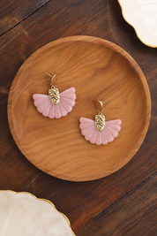 Boucles d’oreilles pendantes Luh rose en forme d’éventail - Bijou photographié dans un décor estival