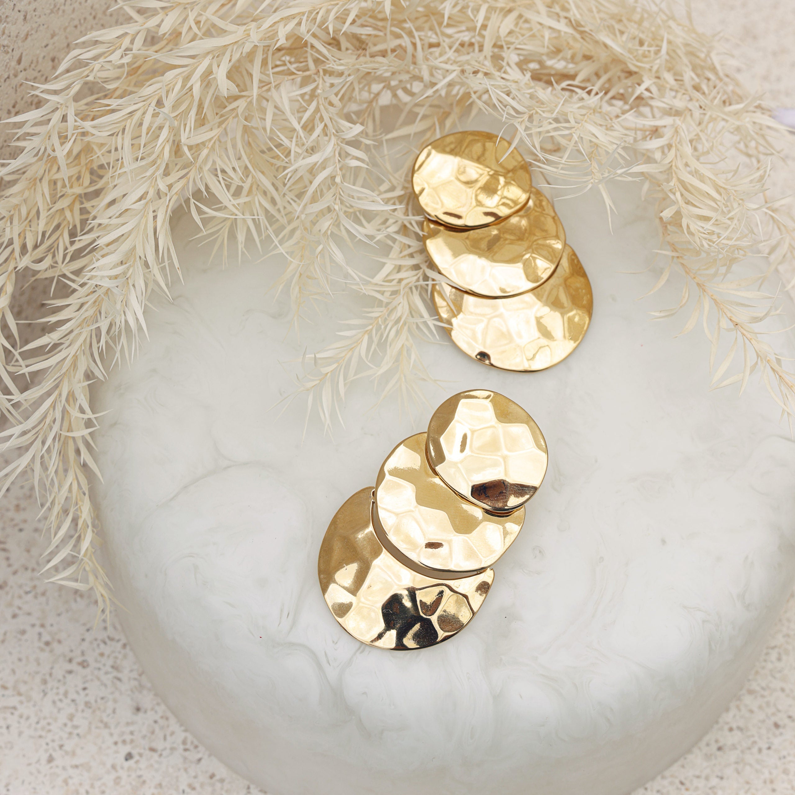 Boucles d’oreilles dorée Ni-Luh - Bijou photographié sur coupole en nacre avec fleurs séchées