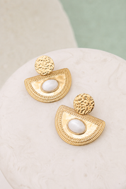 Boucles d’oreilles Solal nacre pendantes formes géométriques texturées ornées d'une nacre ovale - Bijou photographié sur un présentoir en marbre blanc