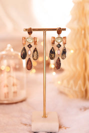 Boucles d'oreilles pendantes dorées Leonie oeil de tigre et pierres naturelles - Bijou photographié sur un présentoir à boucle doré