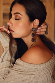 Boucles d'oreilles pendantes dorées Gisèle ornées de cristaux effet oeil de chat - Bijou porté