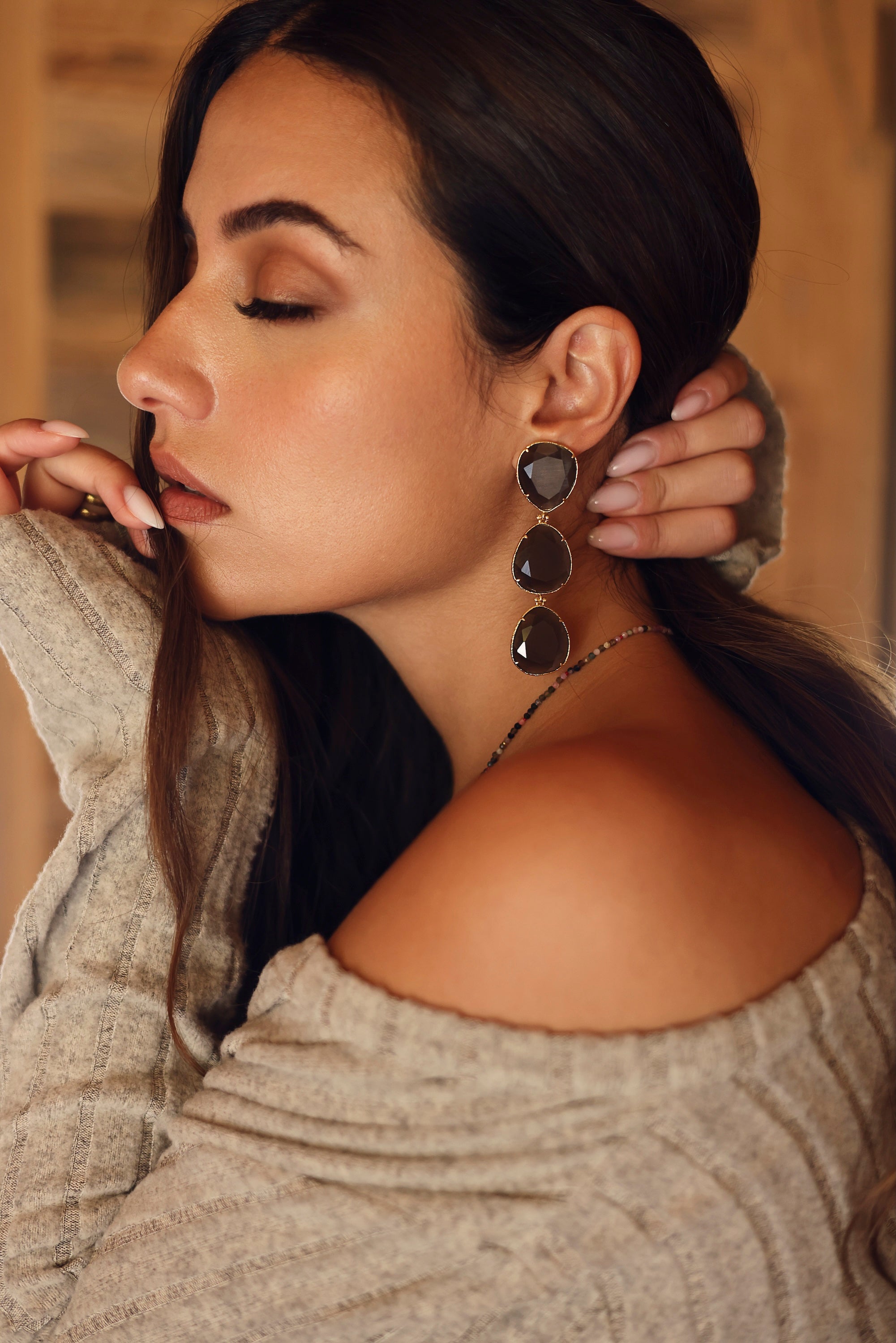 Boucles d'oreilles pendantes dorées Gisèle ornées de cristaux effet oeil de chat - Bijou porté