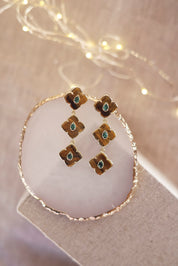 Boucles d'oreilles pendantes dorées Janyce ornées de pierres naturelles - Bijou photographié sur un présentoir