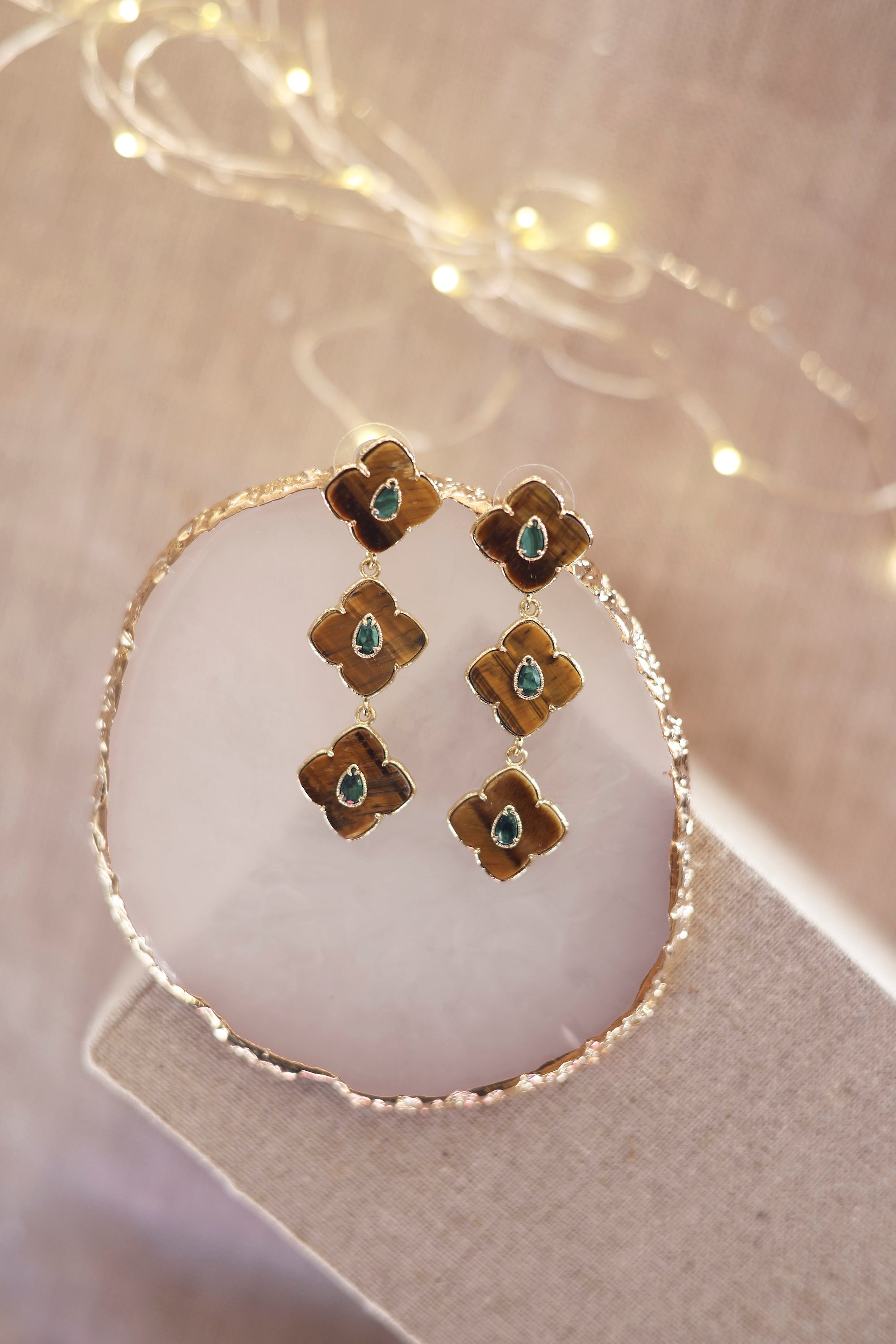 Boucles d'oreilles pendantes dorées Janyce ornées de pierres naturelles - Bijou photographié sur un présentoir