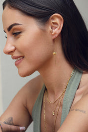 Boucles d'oreilles pendantes dorées Sarya ornées d'un soleil avec un visage - Bijou porté
