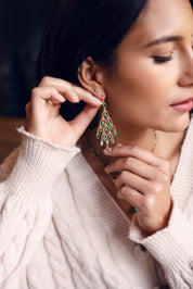 Boucles d'oreilles pendantes dorées Merilia ornées de pierres naturelles disposées en forme de plumes de paon - Bijou porté