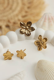Boucles d'oreilles Allie clous dorées fleur - Bijou photographié dans un décor estival