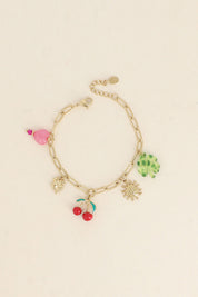 Bracelet doré Cerise pendentifs trèfle, cerise. soleil et coeur - Bijou photographié sur fond beige