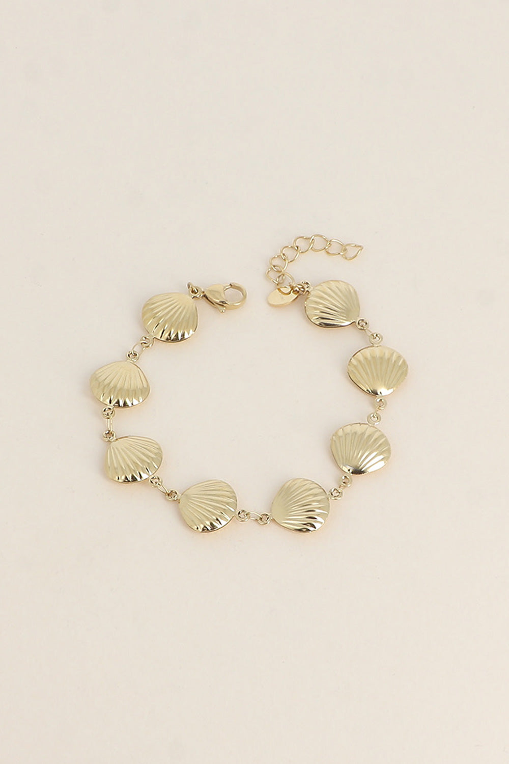 Bracelet doré Iva coquillages - Bijou photographié sur fond beige