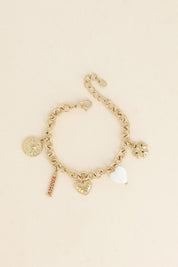 Bracelet maille doré Luz pendentifs soleil, cœur, trèfle, nacre et amulette avec inscription "amour" - Bijou photographié sur fond beige