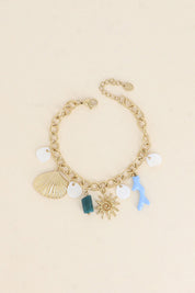 Bracelet doré Maja pendentifs marins dans les tons bleu - Bijou photographié sur fond beige