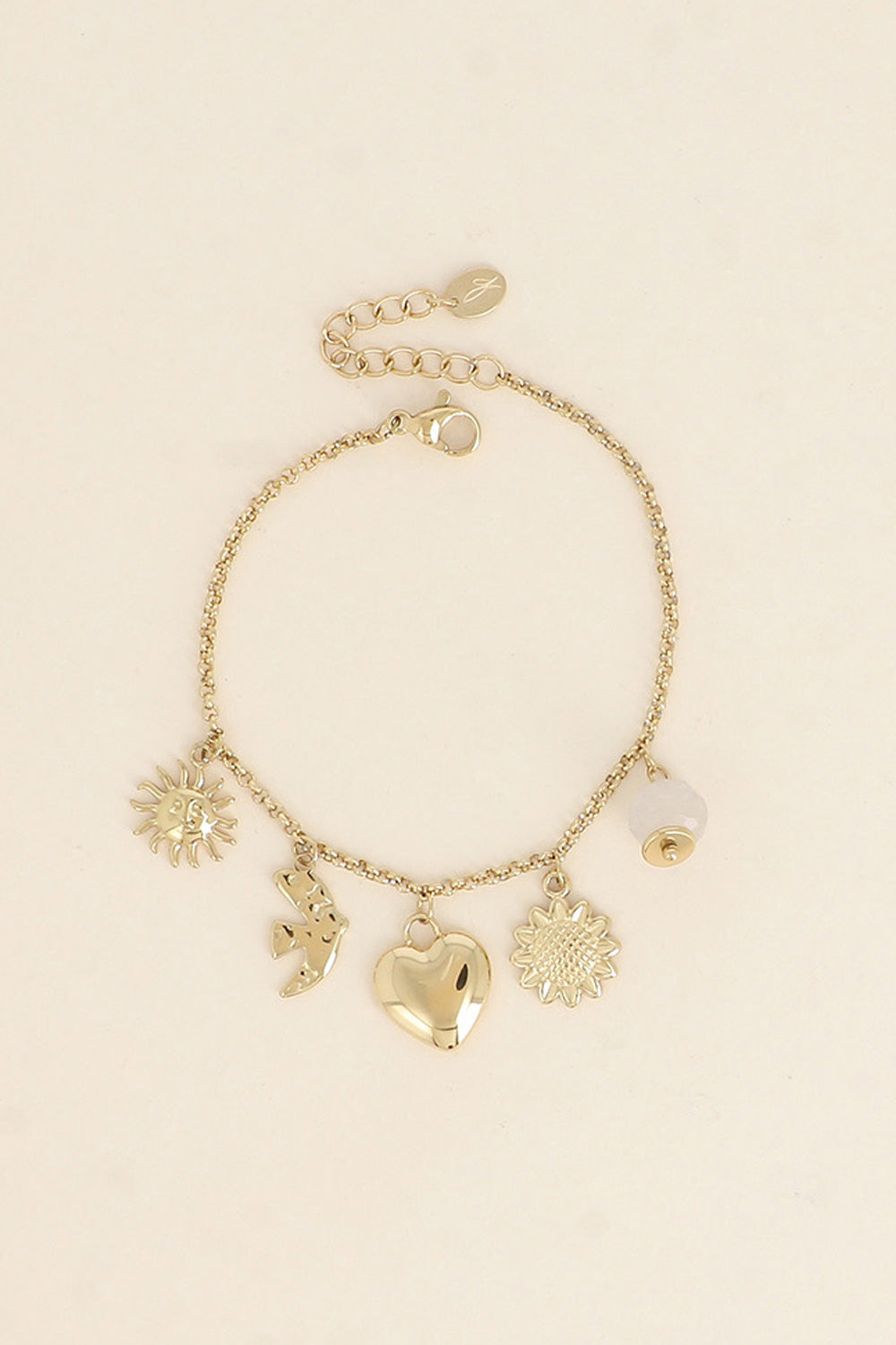 Bracelet doré Lorena chaîne fine avec pendentifs soleil, hirondelle, coeur, tournesol et pierre naturelle - Bijou photographié sur fond beige
