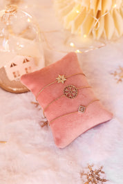Bracelet doré Ivana avec motif losange orné de zircons - Bijou photographié sur un coussin en velours rose
