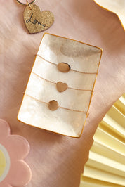 Bracelet personnalisable doré Adelie chaîne fine et médaille en forme de cœur à graver - Bijou photographié dans une coupole en nacre