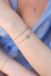 Bracelet doré Ariana orné d'une fleur sertie de zircons turquoises et verts - Bijou porté
